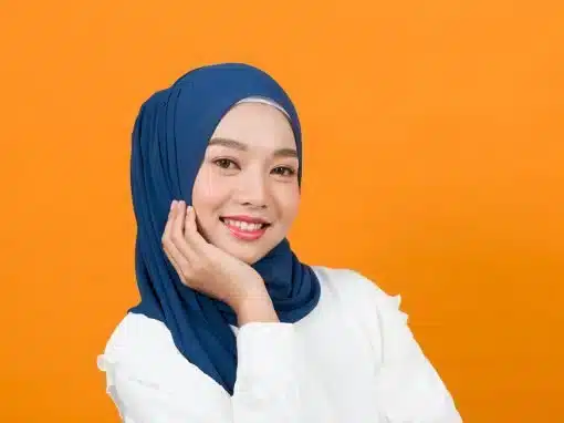 woman-headscarf-smiling-orange-background-shutterstock_1944493501-2876x1306-1-510x382jpg » HCi Smiling young woman in a head scarf with an orange background, happy with her HCi health insurance » HCi