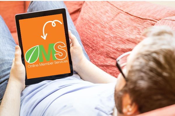 Man reclining on a couch looking at a tablet to access OMS to manage his HCi membership