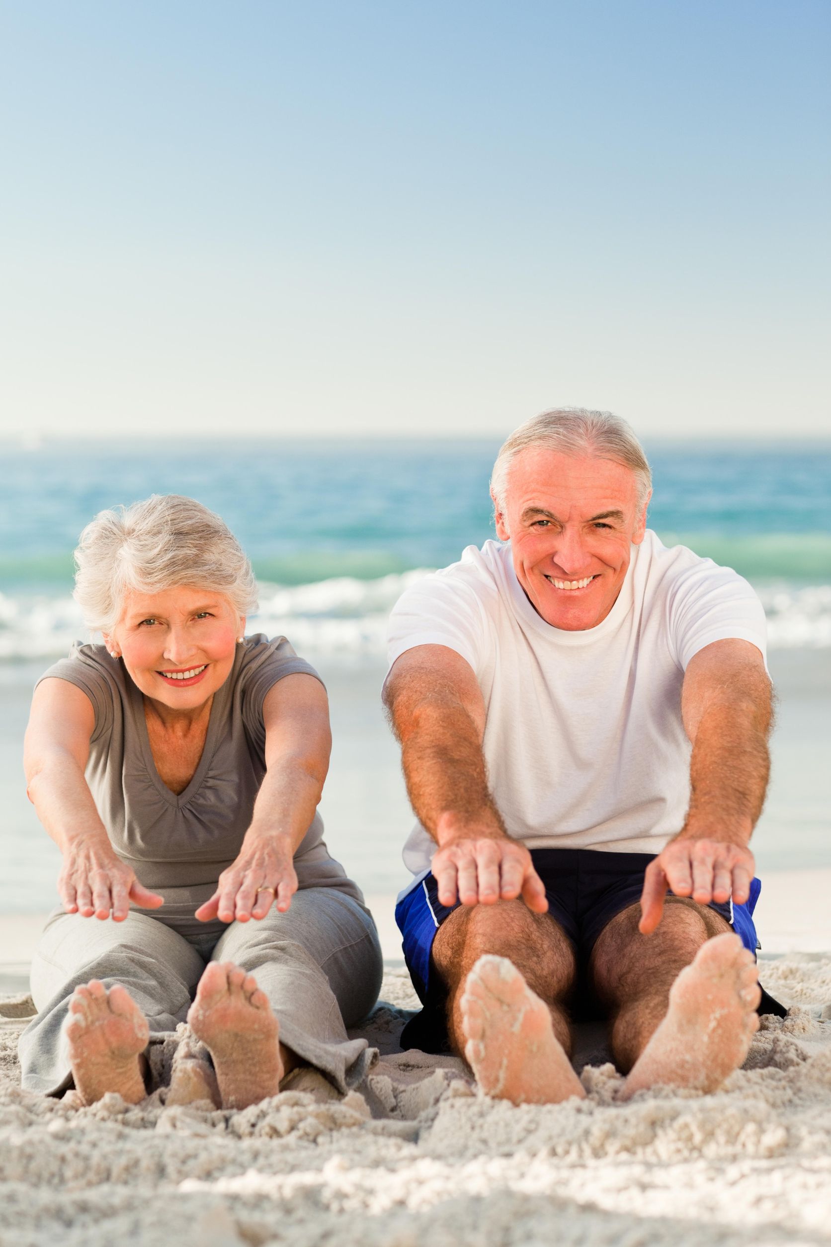 couple_beach_stretching_123rf » HCi Couple at the beach stretching to their toes for health and ahealthy weight for life and a strong heart » HCi