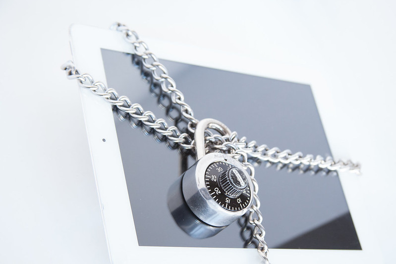 Padlocked chain around a tablet to represent cybersecurity and protecting personal information